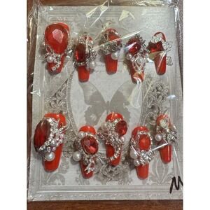 Coffin Red Nails With Large Gems And‎ Charms For A Glamorous Look